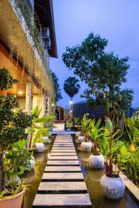 a walkway with potted plants on the side of a building at Kampot Tropical Resort  +24 photos
