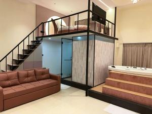 a living room with a staircase and a couch at Collection O Airport Road Formerly Hotel Nano Pod in Surat