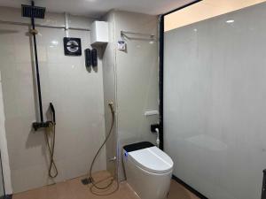 a bathroom with a toilet and a shower at Collection O Airport Road Formerly Hotel Nano Pod in Surat