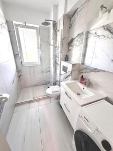 a white bathroom with a sink and a toilet at DOCA Apartments 8 in Otopeni