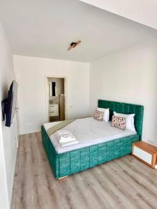 a bedroom with a large green bed in a room at DOCA Apartments 8 in Otopeni