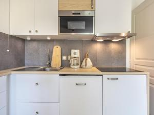 a kitchen with white cabinets and a sink at Les Grizzlis N 20 - 2P6 in Saint-Sorlin-dʼArves