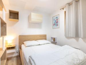 a bedroom with a bed with white sheets and a window at Les Grizzlis N 20 - 2P6 in Saint-Sorlin-dʼArves