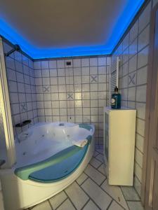 a bath tub in a bathroom with a blue ceiling at 27 Arte Bientina in Bientina