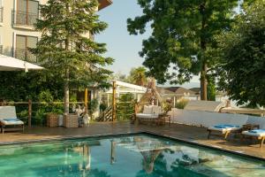 a swimming pool in a yard with chairs and a house at Lale Boutique Hotel in Sapanca