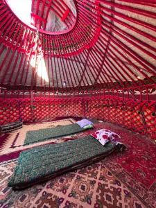 a room with two beds in a red net at Yurtcamp AltynBalyk in Chayek