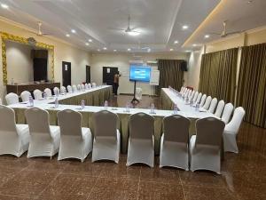 a large conference room with a long table and white chairs at Mr smith hotel in Accra