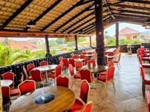 a restaurant with tables and red chairs and tables and chairs at Mr smith hotel in Accra