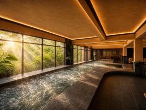 a large room with a pool in a building with windows at Cuc Phuong Mineral Retreat in Ninh Binh