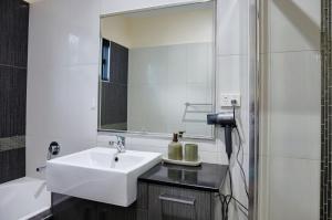 a bathroom with a sink and a mirror at Emerald Oasis in Leanyer