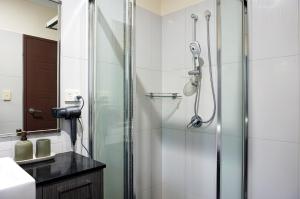 a shower in a bathroom with a glass shower stall at Emerald Oasis in Leanyer