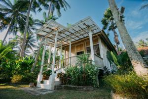a house on the beach with palm trees at Luxury 3-Bedroom Villa with Private Pool in Pulukan