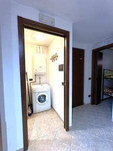a laundry room with a washing machine and a washer at PINK House in Schilpario +5 photos