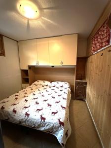 a bedroom with a bed with a comforter with horses on it at PINK House in Schilpario
