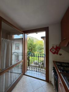 a kitchen with a door open to a balcony at PINK House in Schilpario