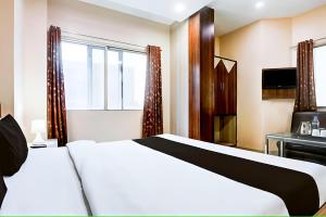 a bedroom with a white bed and a window at Hotel Swarat by TruStay in Satna +11 photos