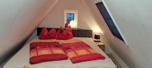a bedroom with a bed with red pillows on it at Ferienwohnung HEIDI in Donauwörth