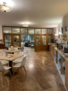 a large room with tables and chairs and a kitchen at Alda A Boira in Jaca
