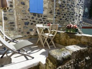 a patio with chairs and a table with a blue window at Brimborion in Alba-la-Romaine