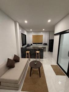 a living room with a couch and a kitchen at Greenway in Hinkong