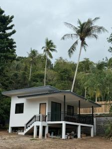 a white house with a palm tree in the background at Greenway in Hinkong