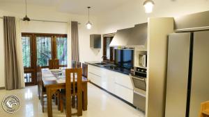 a kitchen with a dining table and a refrigerator at Eagles Hideout Kandy in Bowala