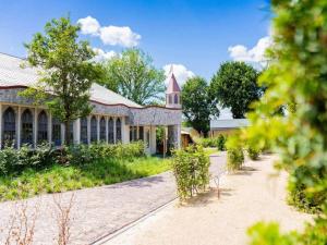 a large stone building with a clock tower on it at Charming Chalet Near Efteling in Kaatsheuvel