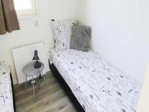 a small bedroom with a bed and a table at Charming Chalet Near Efteling in Kaatsheuvel