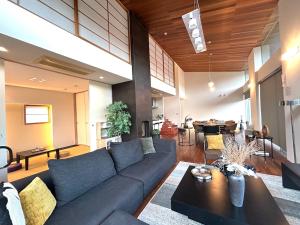 a living room with a blue couch and a table at The SATOYAMA HILLS FK1 in Futtsu