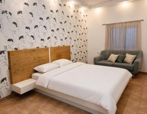 a bedroom with a white bed and a chair at Art & View Family Jacuzzi Suite with Balcony in Maghār
