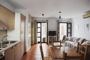eine Küche und ein Wohnzimmer mit Sofa und Tisch in der Unterkunft Apartamento Torre y Sol in Écija