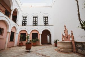 ein Innenhof eines Gebäudes mit einem Brunnen und Pflanzen in der Unterkunft Apartamento Torre y Sol in Écija