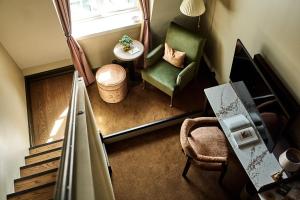 a room with a staircase and a chair and a table at Savoy 1918, a member of Small Luxury Hotels of The World in Oslo