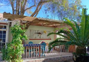 a house with a table and chairs in front of it at The Willow Cottage in Cape Town