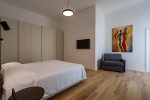 a bedroom with a bed and a chair and a painting at Palazzo Partenope in Vasto