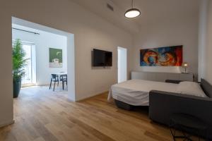 a bedroom with a bed and a table and a tv at Palazzo Partenope in Vasto