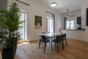a dining room with a table and chairs and a plant at Palazzo Partenope in Vasto