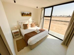 a bedroom with a bed and a large window at 42 on Kavango Unit 24 in Swakopmund