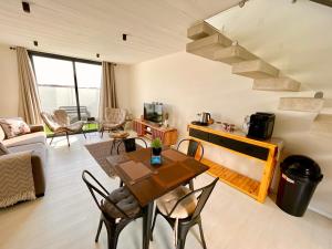 a living room with a table and chairs and a staircase at 42 on Kavango Unit 24 in Swakopmund
