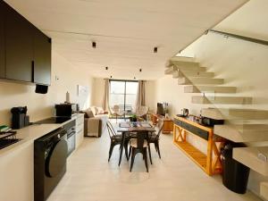 a kitchen and living room with a table and stairs at 42 on Kavango Unit 24 in Swakopmund +10 photos