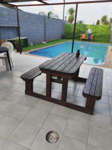a wooden picnic table and bench next to a pool at Van Dyk guest house in Boksburg