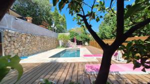 a backyard with a pool and a stone wall at Villa Pibinson 3 chambres - piscine in Mougins