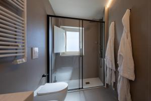 a bathroom with a toilet and a glass shower at Palazzo Partenope in Vasto +77 photos