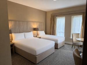 a hotel room with two beds and a table at Wilton Hotel Bray in Bray