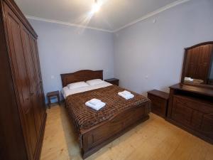a bedroom with a bed with two towels on it at Qristi's Guest House in Kashveti