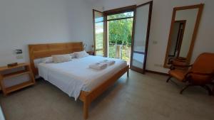 a bedroom with a bed and a chair and a window at Santarcangelo Stay Your Perfect Base in Romagna in Santarcangelo di Romagna