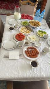 a white table with plates of food on it at Hill Haven Guesthouse in Domje +15 photos