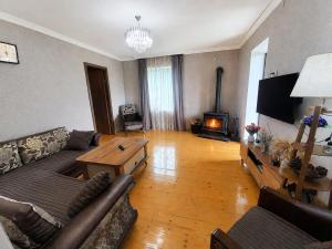 a living room with a couch and a table and a fireplace at Qristi's Guest House in Kashveti