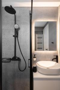 a bathroom with a shower and a sink and a mirror at The Edge Piraeus Luxury Residences in Piraeus +66 photos