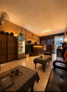a living room with couches a table and a refrigerator at Sharky's Hostel in Pai
